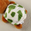 A small, adorable plush turtle with white and green spotted skin and orange feet.