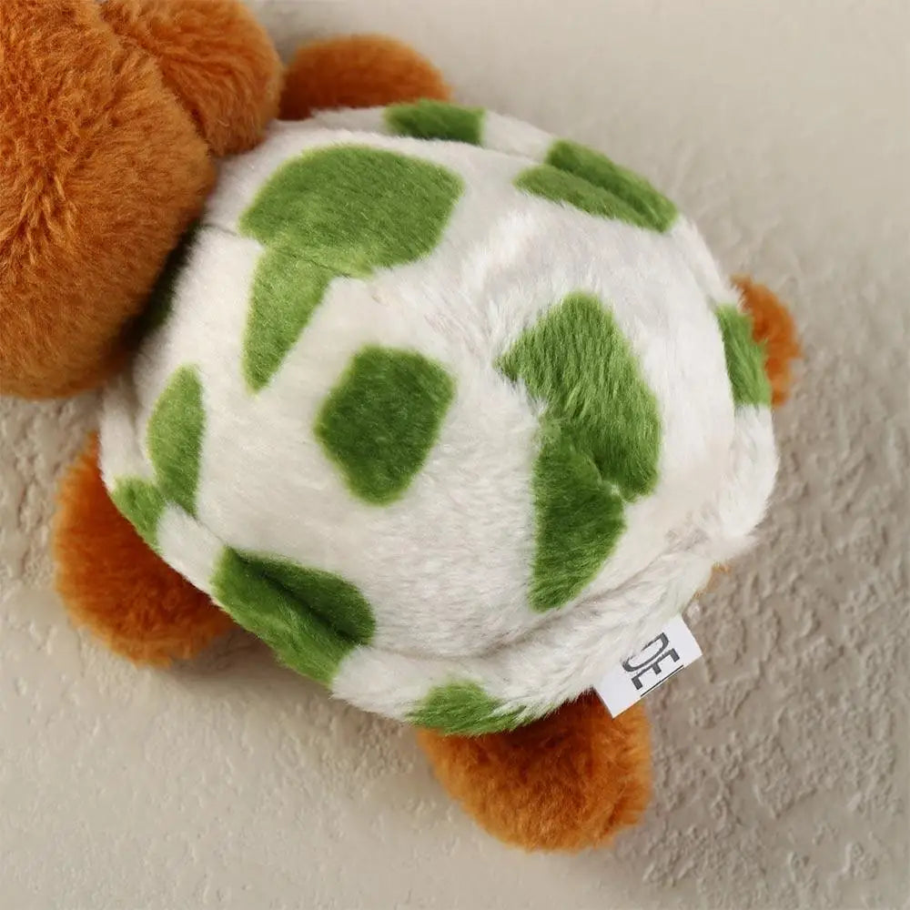 A small, adorable plush turtle with white and green spotted skin and orange feet.
