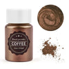 A glass jar of brown pearl powder labeled Coffee with a circular swatch of the powder and loose powder scattered on a white b
