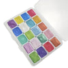 A square tin of 20 watercolor paint colors arranged in a grid inside an open white travel case.
