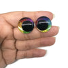 Pair of glitter cartoon safety eyes with iridescent colors displayed in a hand.