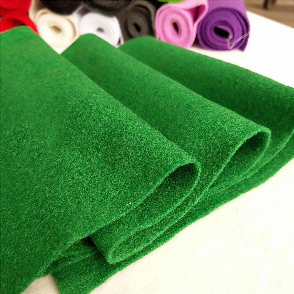 A stack of bright green felt fabric sheets rolled and laid out on a white surface.