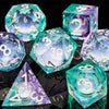 A collection of translucent teal and purple liquid core dice, including d6s, d8s, and d10s, displayed on a dark surface.