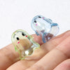 Clear acrylic ghost beads with pink accents resting on a hand