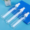 A set of three clear glass refillable travel spray bottles with white pumps resting on a blue surface.