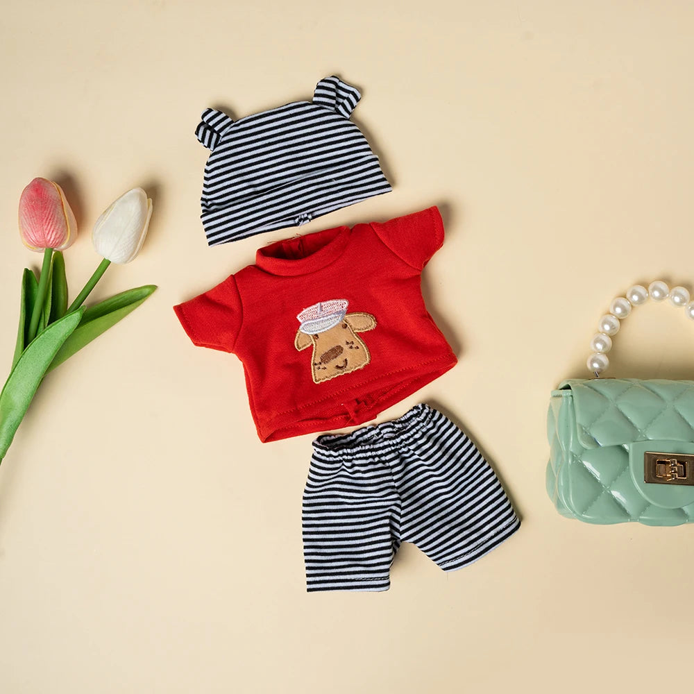 A set of clothing for dolls including a striped top, a red shirt with a brown patch, and striped pants.