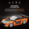 An orange scale model of a sports car built from building blocks, shown in a side view.