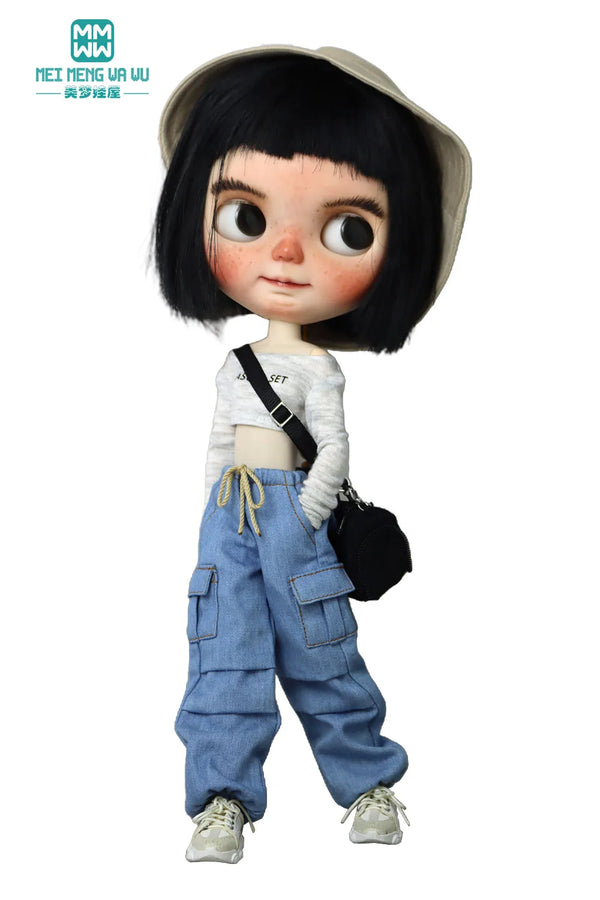 A doll wearing a beige hat, a white top, and blue denim cargo pants.