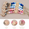 A string of wooden star shapes and silicone beads used as a baby pacifier clip