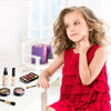 A young girl holds a red ruffled dress and touches her cheek while looking at makeup products.