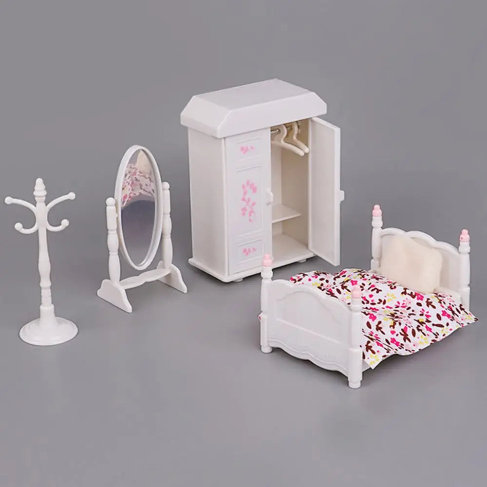 A white 1:12 scale dollhouse furniture set featuring a dresser, mirror, and bed with floral bedding.