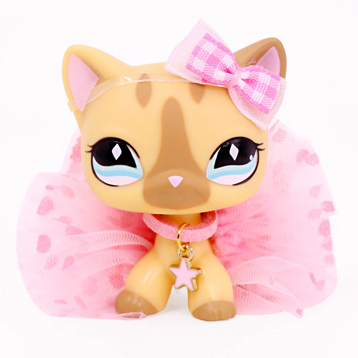 A light orange miniature cat figure with pink accents and a pink bow, displayed against a white background.