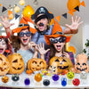 Five people in costumes are holding Halloween squeeze stress balls on a white surface.