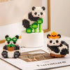 A mini panda building block set featuring black and white blocks with green accents, displayed on a white stand.