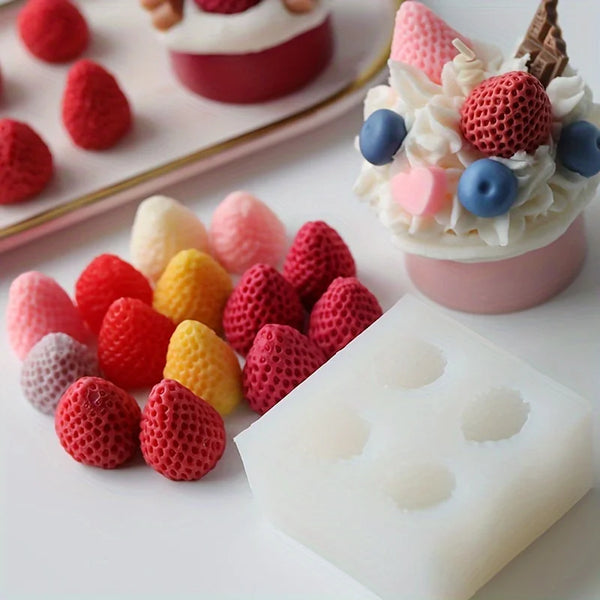A silicone candle mold is shown with various red and pink fruit shapes arranged on a white surface.