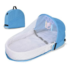 A light blue portable foldable baby bed with a mosquito net and white mattress shown in an open view.