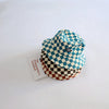 A stack of a kids checkerboard bucket hat in blue and white fabric resting on a white surface.