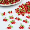 Small red cherry glass charms with gold-colored jump rings and green leaves for jewelry making