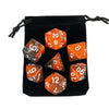 A black storage bag containing a set of polyhedral dice, including a twenty-sided die and other dice.