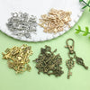 A collection of vintage brass and silver key charms and pendants displayed on a white plate.