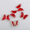 A set of red crystal butterfly charm beads used for jewelry making.
