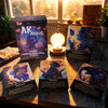 A collection of Akashic Oracle cards and a box displayed on a wooden surface next to a window.