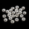 A collection of silver crystal rondelle spacer beads for jewelry making arranged on a black surface.