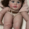 A lifelike reborn baby doll kit featuring painted vinyl parts with soft pink clothing.
