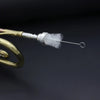 A brass trumpet cleaning kit with a piston and mouthpiece brush is shown against a dark background.