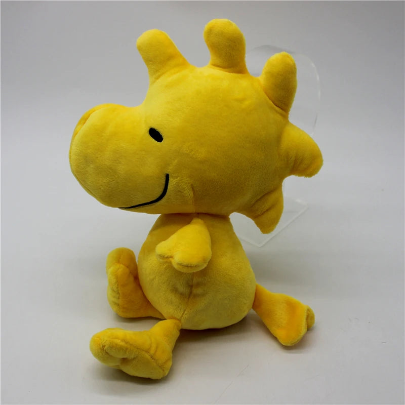 A yellow Peanuts Snoopy plush toy doll with a smiling face, shown against a white background.