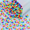 A pile of colorful polymer clay smiling sunflower beads for jewelry making