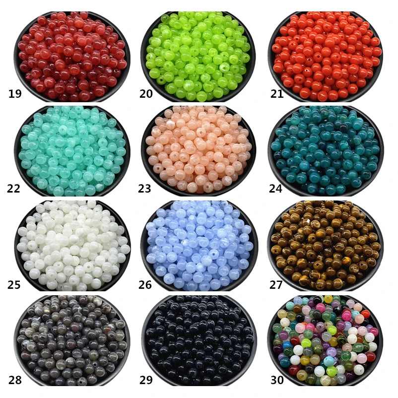 A collection of thirty different colors and shades of acrylic round beads for jewelry making.