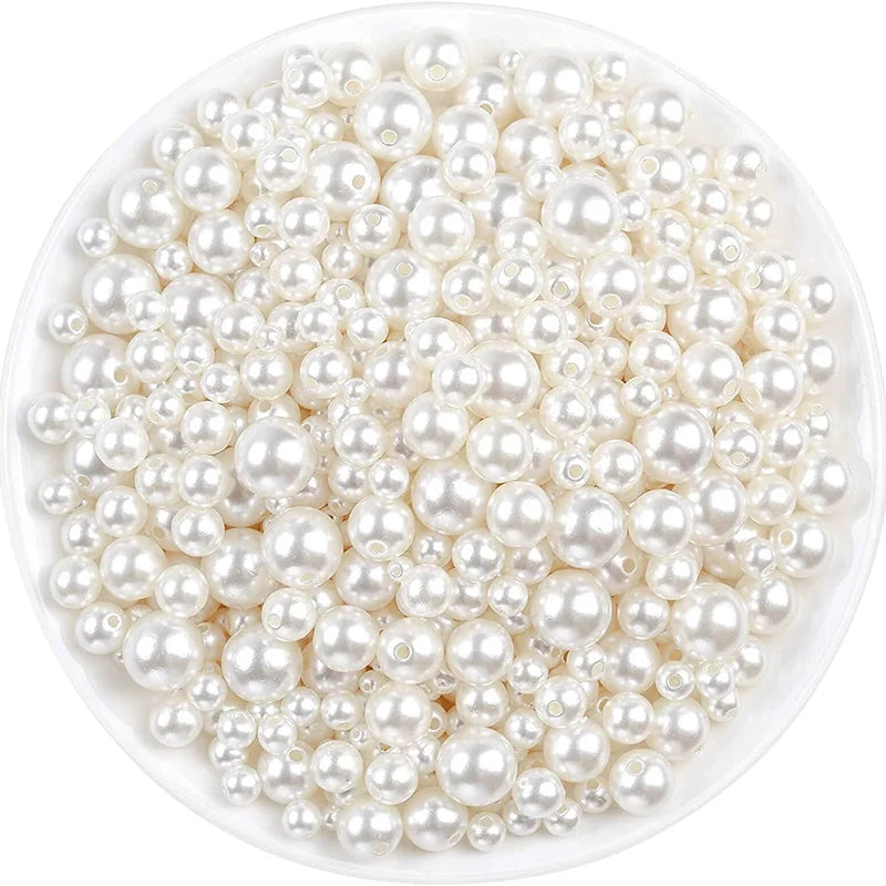 A pile of small, round ivory pearl beads for DIY jewelry making.