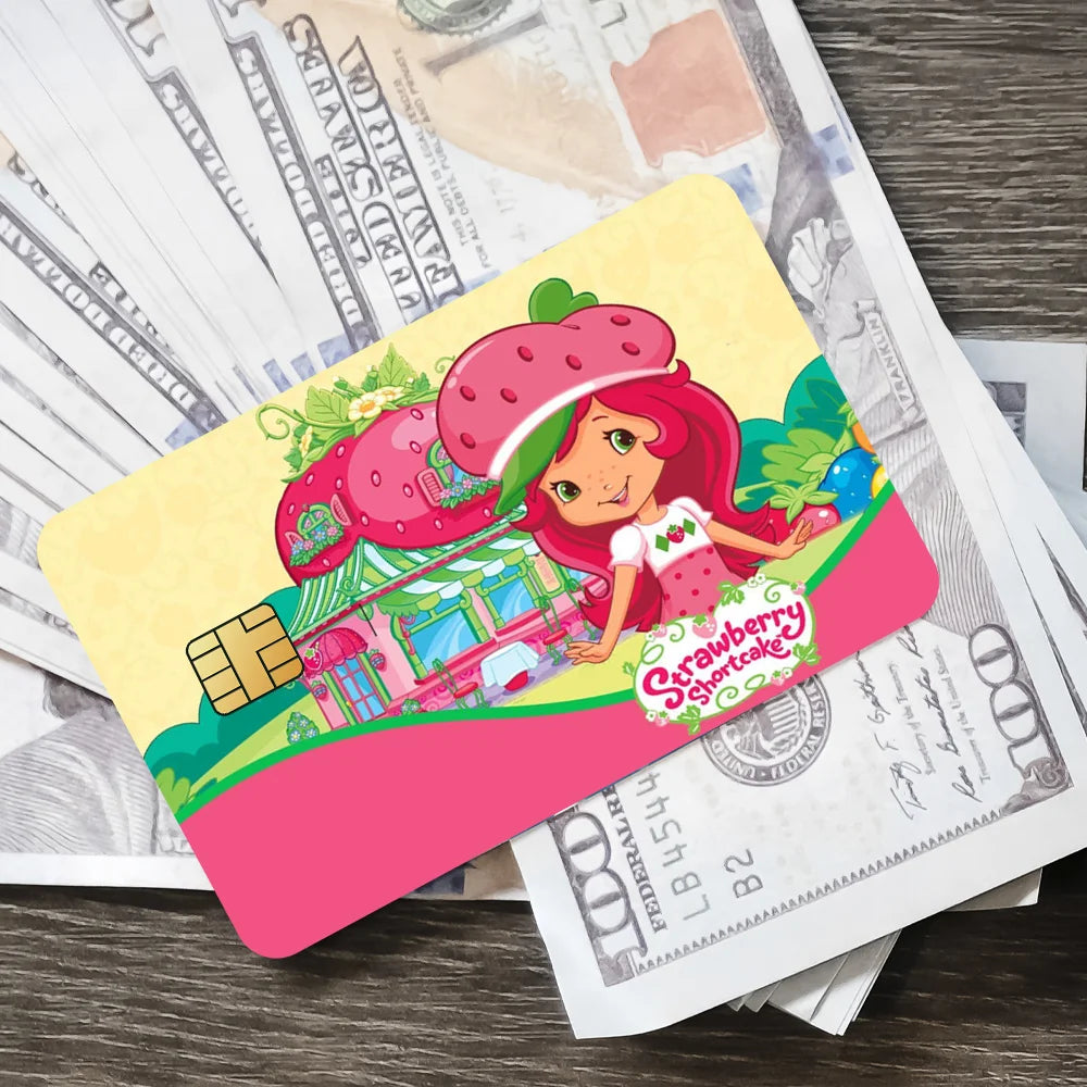 A pink card featuring a cute strawberry and shortcake character on a background of currency.