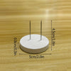 A white circular disc with two metal pins is shown on a wooden surface, illustrating its dimensions.