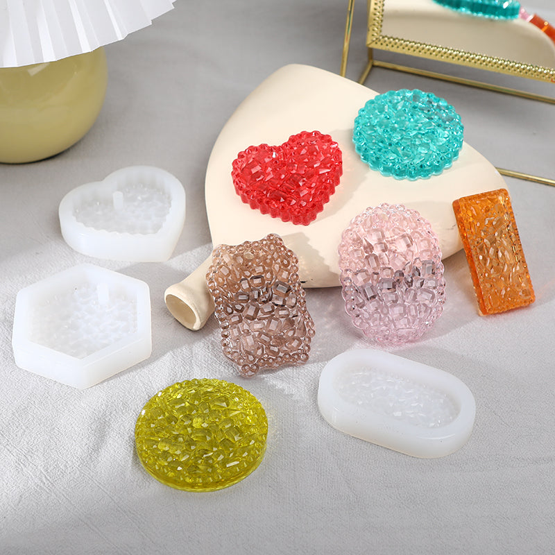A collection of flexible silicone resin molds in various shapes and colors including heart, round, oval, and rectangle forms.