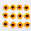 A set of bright orange and black sunflower charms for jewelry making.