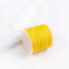 A roll of bright yellow 0.8mm cotton nylon macrame cord for jewelry making and crafts.