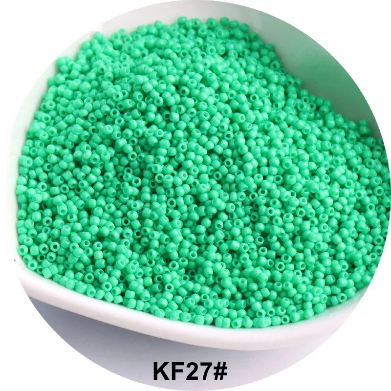 A pile of bright green 1.5mm solid glass seed beads in a white bowl.