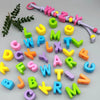 A collection of colorful acrylic letter beads and stringing material for jewelry making