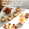 A set of golden and terracotta silicone food-grade afternoon teaware including teapot, cups, and spoons on a white surface.