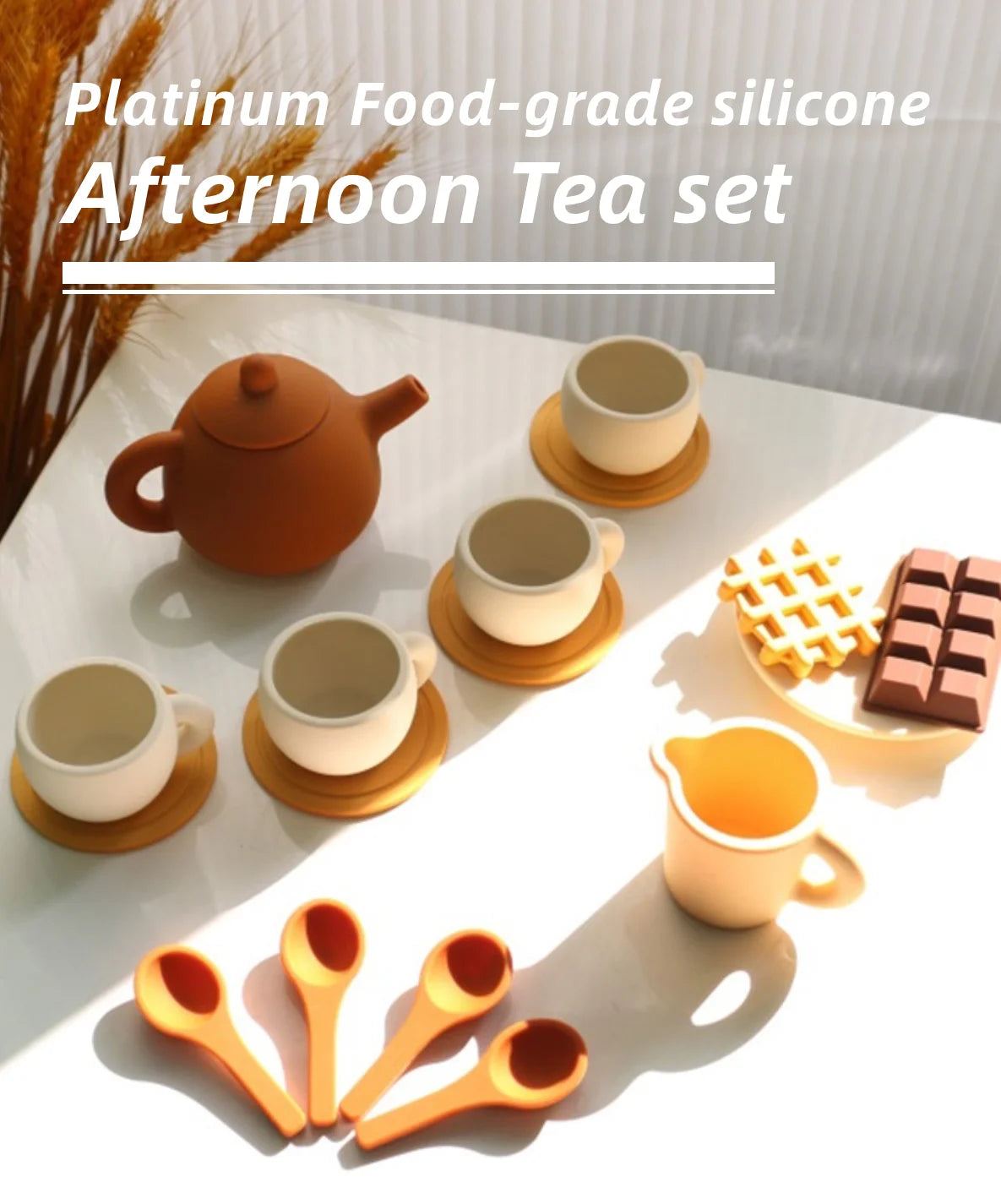 A set of golden and terracotta silicone food-grade afternoon teaware including teapot, cups, and spoons on a white surface.