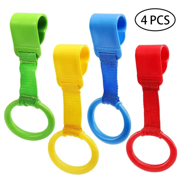 Four colored baby crib pull rings in green, yellow, blue, and red for development and balance.