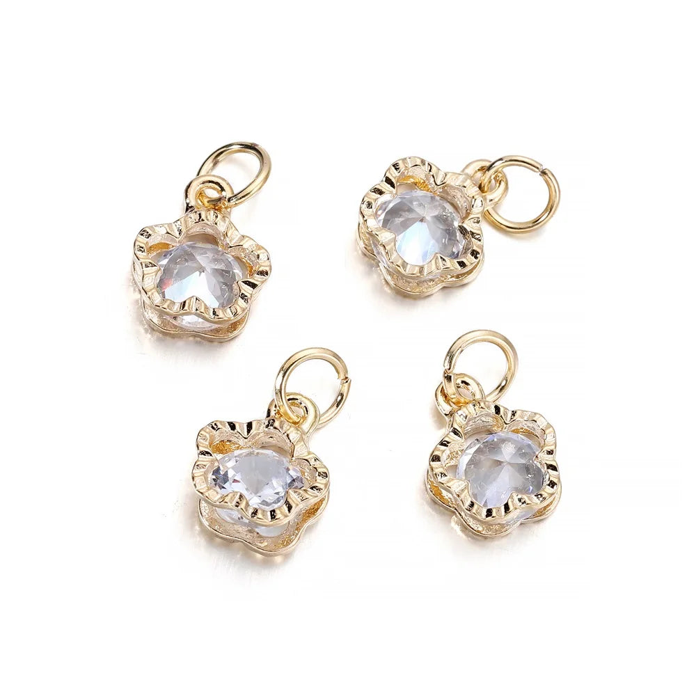 Three gold-toned rhinestone heart charms for jewelry making displayed against a white background.
