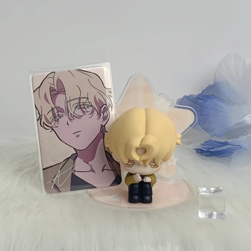 A blind box figure of a light blonde character in a pink and white package with a blue feather background.