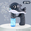 A gray whale bubble gun with a clear bottle of blue bubble solution is shown on a white surface.