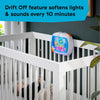 A white crib railing shows an ocean-themed soother device with lights and sounds.