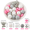 A white bowl filled with various gray and pink silicone beads shaped like cartoon animals for DIY jewelry making