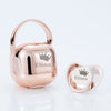 A rose gold personalized baby pacifier with a crown design and storage case.