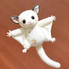 A white plush toy of a mouse with large ears and a long tail, featuring gold star embroidery.